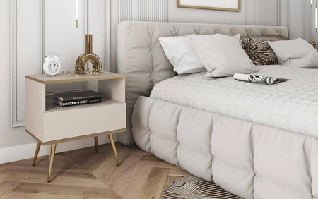 Szafka nocna z szufladą Luxury beżowa elegancki design korpus zwieńczony złotą listwą szafka wsparta na wysokich metalowych nogach